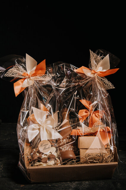 Mand met een chocolade fles, 3 zakjes verschillende producten en een doosje pralines